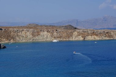 Ağustosta Lindos sahili manzarası. Lindos, Yunanistan 'ın Dodecanese kentindeki Rodos adasında bir arkeolojik alan, bir balıkçı köyü ve eski bir belediyedir.. 