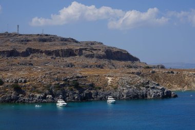 Ağustosta Lindos sahili manzarası. Lindos, Yunanistan 'ın Dodecanese kentindeki Rodos adasında bir arkeolojik alan, bir balıkçı köyü ve eski bir belediyedir.. 