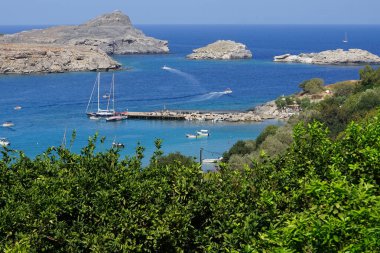 Ağustosta Lindos sahili manzarası. Lindos, Yunanistan 'ın Dodecanese kentindeki Rodos adasında bir arkeolojik alan, bir balıkçı köyü ve eski bir belediyedir..                                