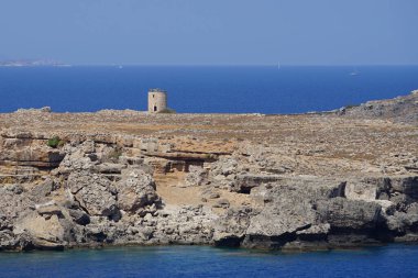Ağustosta Lindos kıyısındaki eski yel değirmeninin manzarası. Lindos, Yunanistan 'ın Dodecanese kentindeki Rodos adasında bir arkeolojik alan, bir balıkçı köyü ve eski bir belediyedir..  