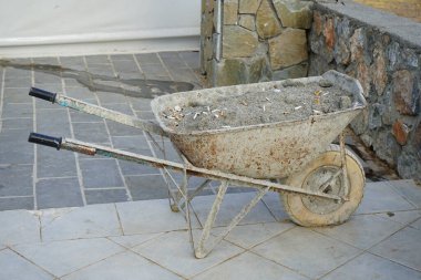 Lindos 'ta kumlu toprak ve sigara izmaritli bir el arabası var. Lindos, Yunanistan 'ın Dodecanese kentindeki Rodos adasında bir arkeolojik alan, bir balıkçı köyü ve eski bir belediyedir..