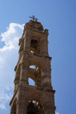 Lindos 'taki Kutsal Bakire Kilisesi' nin çan kulesi. Lindos, Yunanistan 'ın Dodecanese kentindeki Rodos adasında bir arkeolojik alan, bir balıkçı köyü ve eski bir belediyedir.