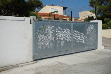 Pefki 'de metal bir kapıya bir balık sürüsü oyulur. Pefkos ya da Pefki, Yunanistan 'ın Rodos Adası' nın doğu kıyısında bulunan ünlü bir sahil beldesidir.