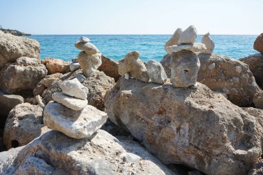 Turistler tarafından Ağustos ayında Pefki 'deki Akdeniz Plakia Sahili' nde yapılmış taş heykelcikler. Pefkos ya da Pefki, Yunanistan 'ın Rodos Adası' nın doğu kıyısında bulunan ünlü bir sahil beldesidir.