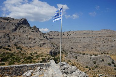 Yunan bayrağı Pefkos veya Pefki 'deki Elías Kilisesi' nin yakınlarındaki bir tepede dalgalanıyor. Yunanistan 'ın ulusal bayrağı resmi olarak ulusal sembollerinden biri olarak tanınıyor ve 5 eşit yatay mavi şeride sahip. Rodos Adası, Yunanistan