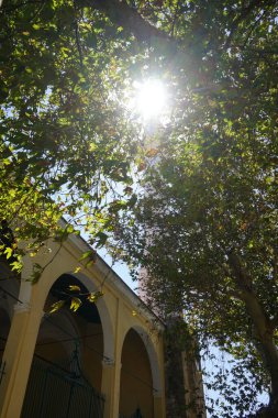 The sun shines through the branches of a tree over Ibrahim Pasha Mosque in the medieval town of Rhodes. Ibrahim Pasha Mosque is an Ottoman-era mosque on the Aegean island of Rhodes, Greece. clipart