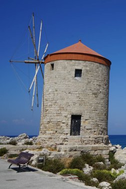 Rhodes 'taki Mandraki limanında yel değirmeni iskelesi. Rodos, Yunanistan 'ın Dodecanese eyaletinde yer alan Rodos adasının önemli bir şehridir. Rodos Adası, Yunanistan