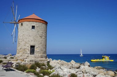 Rhodes 'taki Mandraki limanında yel değirmeni iskelesi. Rodos, Yunanistan 'ın Dodecanese eyaletinde yer alan Rodos adasının önemli bir şehridir. Rodos Adası, Yunanistan