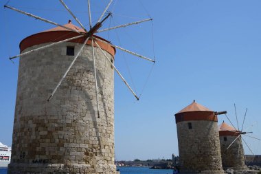 Rhodes 'taki Mandraki limanında yel değirmeni iskelesi. Rodos, Yunanistan 'ın Dodecanese eyaletinde yer alan Rodos adasının önemli bir şehridir. Rodos Adası, Yunanistan