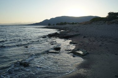 Ulusal park Katafigio Agrias Zois Xortis ile tepenin üzerinde gün batımı, bir Eylül akşamı Lardos 'ta Akdeniz kıyısına bakıyor. Lardos, Yunanistan 'ın Rodos adasının doğu kesiminde yer alan bir Yunan köyüdür. 