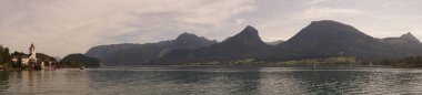 Fotoğraf panoraması. St. Wolfgang Katolik cemaati ve hac kilisesi Yukarı Avusturya 'nın Gmunden ilçesine bağlı Salzkammergut' taki St. Wolfgang 'da bulunan bir kilise binasıdır. Büyük bina doğrudan Wolfgang Gölü 'nün üzerindeki bir kayanın üzerinde duruyor..