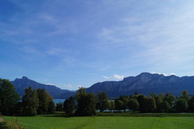 Mondsee Gölü manzarası, Eylül ayında Mondsee 'den Alp Dağları ile çevrili. Mondsee, Salzkammergut 'un Yukarı Avusturya bölgesinde bulunan bir göldür. Avusturya