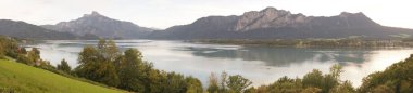Fotoğraf panoraması. Mondsee Gölü 'nün Alplerle çevrili olduğu güzel bir eylül manzarası. Mondsee, Salzkammergut 'un Yukarı Avusturya bölgesinde bulunan bir göldür. Avusturya 