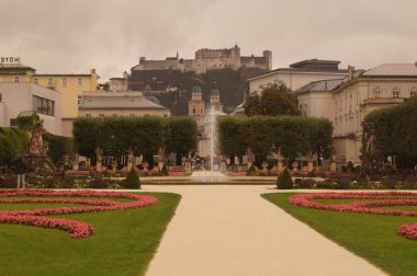 Eylül ayında çiçek tarhlı Mirabell Gardens manzarası, fıskiye ve arka planda Hohensalzburg Kalesi. Mirabell Bahçeleri, Avusturya 'nın Salzburg kentindeki Mirabell Sarayı' nın bahçesidir.. 