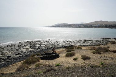 İspanya 'nın Fuerteventura adasındaki tatil beldesi Costa Calma' daki kumsaldaki rüzgara karşı korumak için taşlardan yapılmış bir yapı.. 