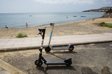 Costa Calma, Fuerteventura, İspanya - 23 Ekim 2022: Kiralık scooterlar Ekim ayında Costa Calma sahilinin yanındaki Atlantik Okyanusu kıyısında park edilmiştir..