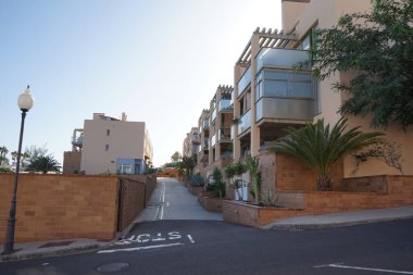 Esquinzo, Fuerteventura, Las Palmas, İspanya 'daki turistik tatil beldesinde modern mimari evleri bulunan cadde manzarası.