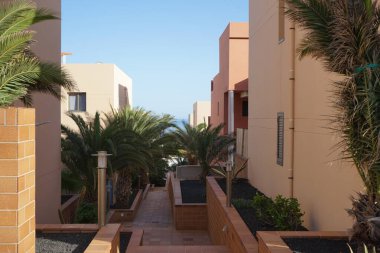 Esquinzo, Fuerteventura, Las Palmas, İspanya 'daki turistik tatil beldesinde modern mimari evleri bulunan cadde manzarası.