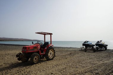 Costa Calma, Fuerteventura, İspanya - 22 Ekim 2022: Küçük bir MITSUBISHI MT20 traktörü Atlantik Okyanusu 'ndan Matas Körfezi kıyısına iki jet ski çıkardı. Las Palmas, Kanarya Adaları.