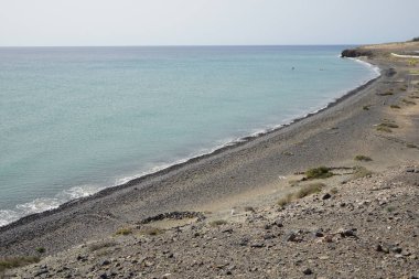 Matas Körfezi 'ndeki Atlantik Okyanusu yakınlarındaki Playas de Matas Blancas plajında istiflenmiş taşlar turistleri rüzgardan korur. Costa Calma, Fuerteventura, Las Palmas, Kanarya Adaları, İspanya.