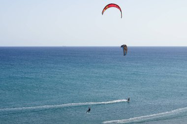 Kiteboardcular sörf tahtalarını Matas Körfezi 'ndeki Atlantik Okyanusu' nun dalgalarından geçiriyorlar. Uçurtma sörfü ya da uçurtma uçurmak rüzgar enerjisi gerektiren bir spordur. Costa Calma, Fuerteventura, Las Palmas, Kanarya Adaları, İspanya.  