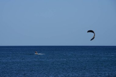 Bir uçurtma sörfçüsü, Matas Bay 'de, Matas de Blancas plajı boyunca sonbaharda Atlantik Okyanusu' nun dalgaları üzerinde sörf tahtasına biner. Uçurtma sörfü ya da uçurtma uçurmak rüzgar enerjisi gerektiren bir spordur. Costa Calma, Fuerteventura, Kanarya Adaları.