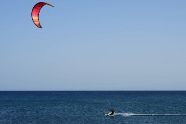 Bir uçurtma sörfçüsü, Matas Bay 'de, Matas de Blancas plajı boyunca sonbaharda Atlantik Okyanusu' nun dalgaları üzerinde sörf tahtasına biner. Uçurtma sörfü ya da uçurtma uçurmak rüzgar enerjisi gerektiren bir spordur. Costa Calma, Fuerteventura, Kanarya Adaları.