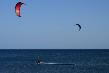 Kiteboardcular sörf tahtalarını Matas Körfezi 'ndeki Atlantik Okyanusu' nun dalgalarından geçiriyorlar. Uçurtma sörfü ya da uçurtma uçurmak rüzgar enerjisi gerektiren bir spordur. Costa Calma, Fuerteventura, Las Palmas, Kanarya Adaları, İspanya.  