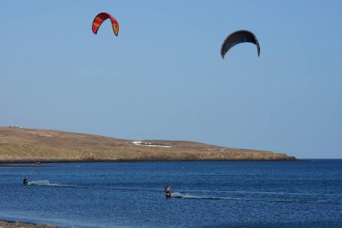 Kiteboardcular sörf tahtalarını Matas Körfezi 'ndeki Atlantik Okyanusu' nun dalgalarından geçiriyorlar. Uçurtma sörfü ya da uçurtma uçurmak rüzgar enerjisi gerektiren bir spordur. Costa Calma, Fuerteventura, Las Palmas, Kanarya Adaları, İspanya.  
