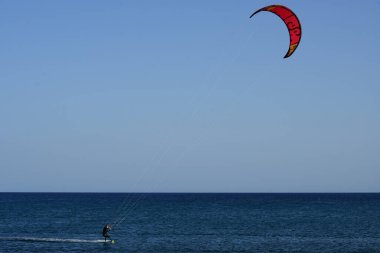 Bir uçurtma sörfçüsü, Matas Bay 'de, Matas de Blancas plajı boyunca sonbaharda Atlantik Okyanusu' nun dalgaları üzerinde sörf tahtasına biner. Uçurtma sörfü ya da uçurtma uçurmak rüzgar enerjisi gerektiren bir spordur. Costa Calma, Fuerteventura, Kanarya Adaları.
