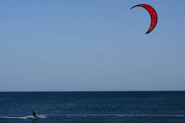 Bir uçurtma sörfçüsü, Matas Bay 'de, Matas de Blancas plajı boyunca sonbaharda Atlantik Okyanusu' nun dalgaları üzerinde sörf tahtasına biner. Uçurtma sörfü ya da uçurtma uçurmak rüzgar enerjisi gerektiren bir spordur. Costa Calma, Fuerteventura, Kanarya Adaları.