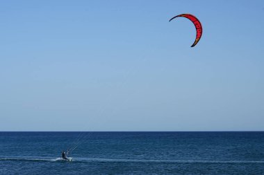 Bir uçurtma sörfçüsü, Matas Bay 'de, Matas de Blancas plajı boyunca sonbaharda Atlantik Okyanusu' nun dalgaları üzerinde sörf tahtasına biner. Uçurtma sörfü ya da uçurtma uçurmak rüzgar enerjisi gerektiren bir spordur. Costa Calma, Fuerteventura, Kanarya Adaları.
