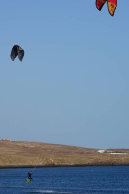 Kiteboardcular sörf tahtalarını Matas Körfezi 'ndeki Atlantik Okyanusu' nun dalgalarından geçiriyorlar. Uçurtma sörfü ya da uçurtma uçurmak rüzgar enerjisi gerektiren bir spordur. Costa Calma, Fuerteventura, Las Palmas, Kanarya Adaları, İspanya.  