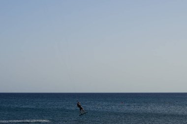 Bir uçurtma sörfçüsü, Matas Bay 'de, Matas de Blancas plajı boyunca sonbaharda Atlantik Okyanusu' nun dalgaları üzerinde sörf tahtasına biner. Uçurtma sörfü ya da uçurtma uçurmak rüzgar enerjisi gerektiren bir spordur. Costa Calma, Fuerteventura, Kanarya Adaları.