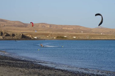 Kiteboardcular sörf tahtalarını Matas Körfezi 'ndeki Atlantik Okyanusu' nun dalgalarından geçiriyorlar. Uçurtma sörfü ya da uçurtma uçurmak rüzgar enerjisi gerektiren bir spordur. Costa Calma, Fuerteventura, Las Palmas, Kanarya Adaları, İspanya. 