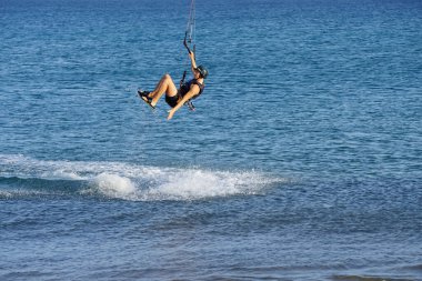 Bir uçurtma sörfçüsü, Matas Bay 'de, Matas de Blancas plajı boyunca sonbaharda Atlantik Okyanusu' nun dalgaları üzerinde sörf tahtasına biner. Uçurtma sörfü ya da uçurtma uçurmak rüzgar enerjisi gerektiren bir spordur. Costa Calma, Fuerteventura, Kanarya Adaları.