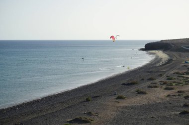 Matas Körfezi 'nde Atlantik Okyanusu' nun dalgalarında sörf tahtalarına binen bir kanat folyosu ve uçurtmacılar. Uçurtma sörfü ya da uçurtma uçurmak rüzgar enerjisi gerektiren bir spordur. Costa Calma, Fuerteventura, Las Palmas, İspanya.