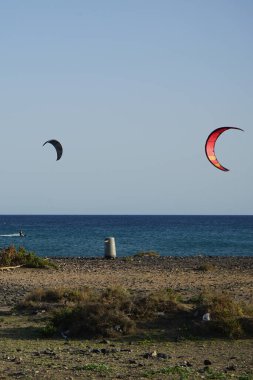 Kiteboardcular sörf tahtalarını Matas Körfezi 'ndeki Atlantik Okyanusu' nun dalgalarından geçiriyorlar. Uçurtma sörfü ya da uçurtma uçurmak rüzgar enerjisi gerektiren bir spordur. Costa Calma, Fuerteventura, Las Palmas, Kanarya Adaları, İspanya.  