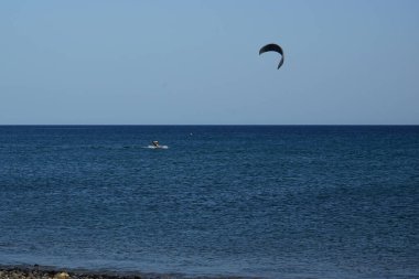 Bir uçurtma sörfçüsü, Matas Bay 'de, Matas de Blancas plajı boyunca sonbaharda Atlantik Okyanusu' nun dalgaları üzerinde sörf tahtasına biner. Uçurtma sörfü ya da uçurtma uçurmak rüzgar enerjisi gerektiren bir spordur. Costa Calma, Fuerteventura, Kanarya Adaları.  