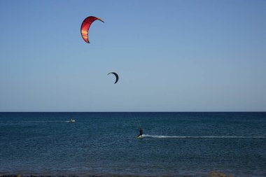 Kiteboardcular sörf tahtalarını Matas Körfezi 'ndeki Atlantik Okyanusu' nun dalgalarından geçiriyorlar. Uçurtma sörfü ya da uçurtma uçurmak rüzgar enerjisi gerektiren bir spordur. Costa Calma, Fuerteventura, Las Palmas, Kanarya Adaları, İspanya.  
