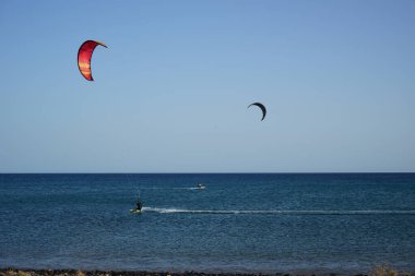 Kiteboardcular sörf tahtalarını Matas Körfezi 'ndeki Atlantik Okyanusu' nun dalgalarından geçiriyorlar. Uçurtma sörfü ya da uçurtma uçurmak rüzgar enerjisi gerektiren bir spordur. Costa Calma, Fuerteventura, Las Palmas, Kanarya Adaları, İspanya.  