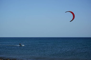Bir uçurtma sörfçüsü, Matas Bay 'de, Matas de Blancas plajı boyunca sonbaharda Atlantik Okyanusu' nun dalgaları üzerinde sörf tahtasına biner. Uçurtma sörfü ya da uçurtma uçurmak rüzgar enerjisi gerektiren bir spordur. Costa Calma, Fuerteventura, Kanarya Adaları.  