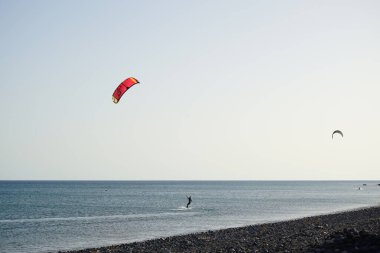 Kiteboardcular sörf tahtalarını Matas Körfezi 'ndeki Atlantik Okyanusu' nun dalgalarından geçiriyorlar. Uçurtma sörfü ya da uçurtma uçurmak rüzgar enerjisi gerektiren bir spordur. Costa Calma, Fuerteventura, Las Palmas, Kanarya Adaları, İspanya.  