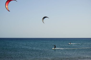 Kiteboardcular sörf tahtalarını Matas Körfezi 'ndeki Atlantik Okyanusu' nun dalgalarından geçiriyorlar. Uçurtma sörfü ya da uçurtma uçurmak rüzgar enerjisi gerektiren bir spordur. Costa Calma, Fuerteventura, Las Palmas, Kanarya Adaları, İspanya.  