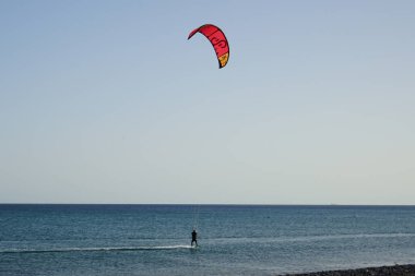 Bir uçurtma sörfçüsü, Matas Bay 'de, Matas de Blancas plajı boyunca sonbaharda Atlantik Okyanusu' nun dalgaları üzerinde sörf tahtasına biner. Uçurtma sörfü ya da uçurtma uçurmak rüzgar enerjisi gerektiren bir spordur. Costa Calma, Fuerteventura, Kanarya Adaları. 