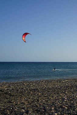 Bir uçurtma sörfçüsü, Matas Bay 'de, Matas de Blancas plajı boyunca sonbaharda Atlantik Okyanusu' nun dalgaları üzerinde sörf tahtasına biner. Uçurtma sörfü ya da uçurtma uçurmak rüzgar enerjisi gerektiren bir spordur. Costa Calma, Fuerteventura, Kanarya Adaları. 