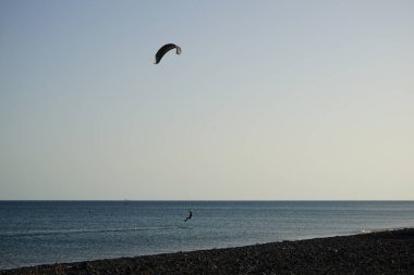Bir uçurtma sörfçüsü, Matas Bay 'de, Matas de Blancas plajı boyunca sonbaharda Atlantik Okyanusu' nun dalgaları üzerinde sörf tahtasına biner. Uçurtma sörfü ya da uçurtma uçurmak rüzgar enerjisi gerektiren bir spordur. Costa Calma, Fuerteventura, Kanarya Adaları.  