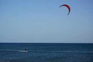 Bir uçurtma sörfçüsü, Matas Bay 'de, Matas de Blancas plajı boyunca sonbaharda Atlantik Okyanusu' nun dalgaları üzerinde sörf tahtasına biner. Uçurtma sörfü ya da uçurtma uçurmak rüzgar enerjisi gerektiren bir spordur. Costa Calma, Fuerteventura, Kanarya Adaları.  