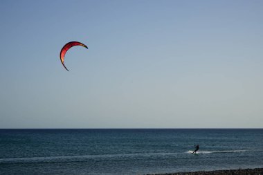 Bir uçurtma sörfçüsü, Matas Bay 'de, Matas de Blancas plajı boyunca sonbaharda Atlantik Okyanusu' nun dalgaları üzerinde sörf tahtasına biner. Uçurtma sörfü ya da uçurtma uçurmak rüzgar enerjisi gerektiren bir spordur. Costa Calma, Fuerteventura, Kanarya Adaları.  