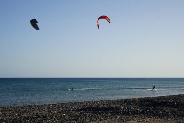 Kiteboardcular sörf tahtalarını Matas Körfezi 'ndeki Atlantik Okyanusu' nun dalgalarından geçiriyorlar. Uçurtma sörfü ya da uçurtma uçurmak rüzgar enerjisi gerektiren bir spordur. Costa Calma, Fuerteventura, Las Palmas, Kanarya Adaları, İspanya. 